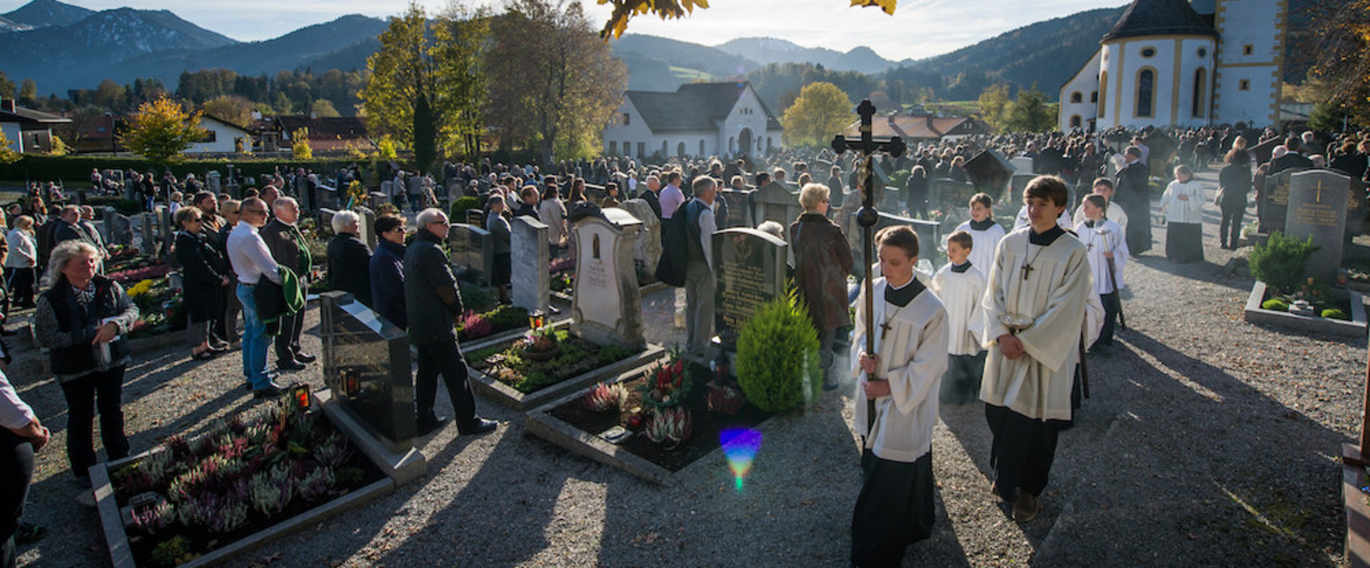 Pfarrer Peter Hagsbacher vom Pfarrverband Schliersee und seine Ministranten ziehen an Allerheiligen, den 1. November 2014,  in Schliersee beim traditionellen Gräberumgang zu Allerheiligen über den Friedhof der Kirche St. Martin und segnen die Gräber 