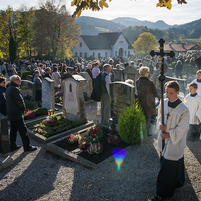 Pfarrer Peter Hagsbacher vom Pfarrverband Schliersee und seine Ministranten ziehen an Allerheiligen, den 1. November 2014,  in Schliersee beim traditionellen Gräberumgang zu Allerheiligen über den Friedhof der Kirche St. Martin und segnen die Gräber 