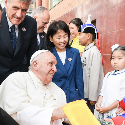 Kardinal Giorgio Marengo (l.), Apostolischer Präfekt von Ulan Bator, und Kinder in traditioneller Tracht, beim Empfang für Papst Franziskus am 1. September 2023 vor der Apostolischen Präfektur Ulanbaatar in Ulan Bator (Mongolei).