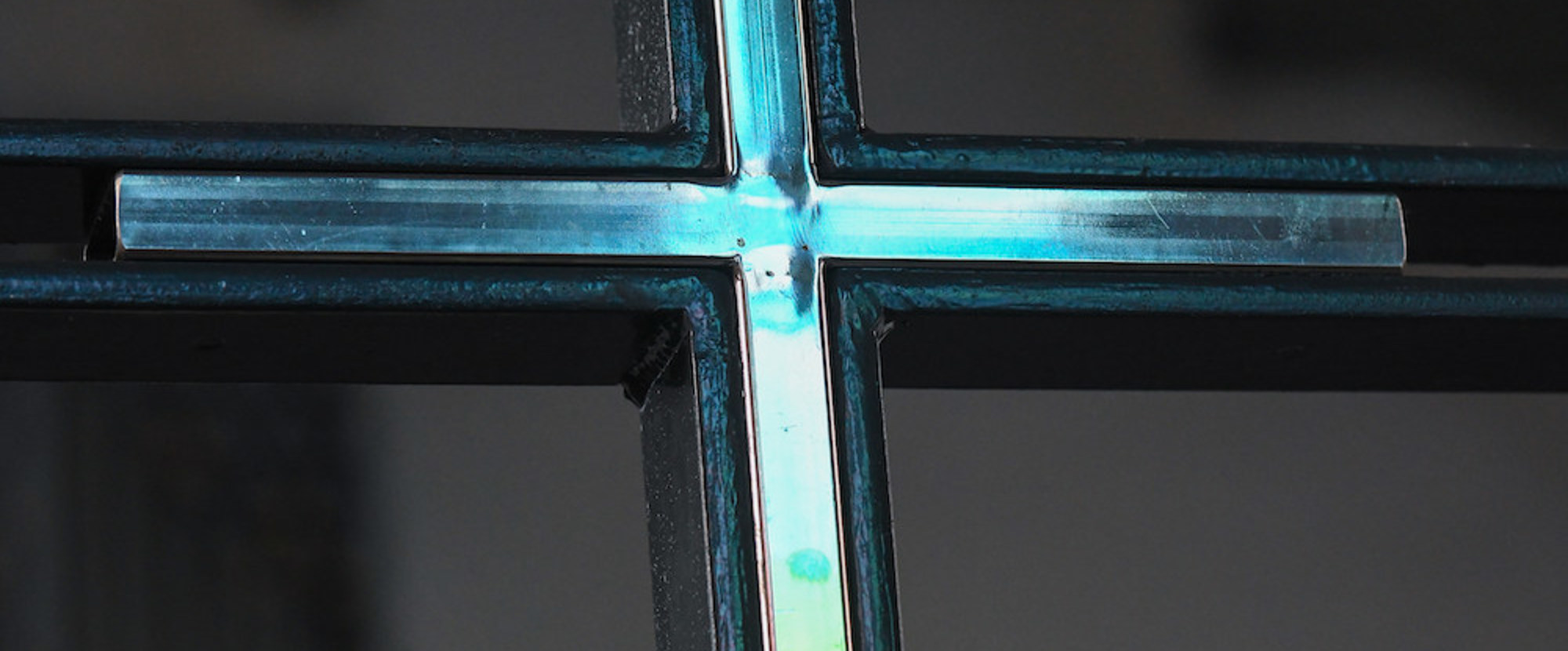 Blaues Licht spiegelt sich im Altarkreuz im Innenraum der Kirche Sankt Ludgerus am 3. Juli 2020 in Norderney.