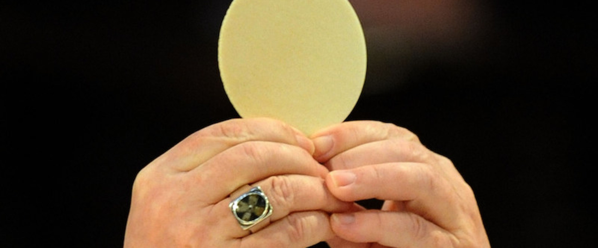 Erzbischof Reinhard Marx hält bei einem Gottesdienst in Regensburg am 28. Februar 2012 während der Wandlung die große Hostie in die Höhe. Dieses Bild ist Teil des Features 'Eucharistie'.